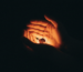 Two hands carefully holding a glowing ember, symbolizing the process of rekindling intimacy and passion through couples therapy.