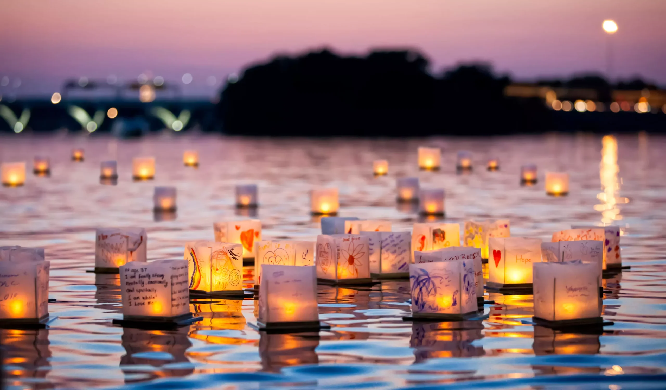 Two glowing lanterns floating close together on calm water, representing the peaceful and deep connection restored through intimacy counseling.