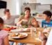 A happy blended family eating dinner together, representing the unity and new traditions built through family counseling.