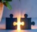 Two wooden puzzle pieces with golden light between them, representing conflict resolution in marriage.